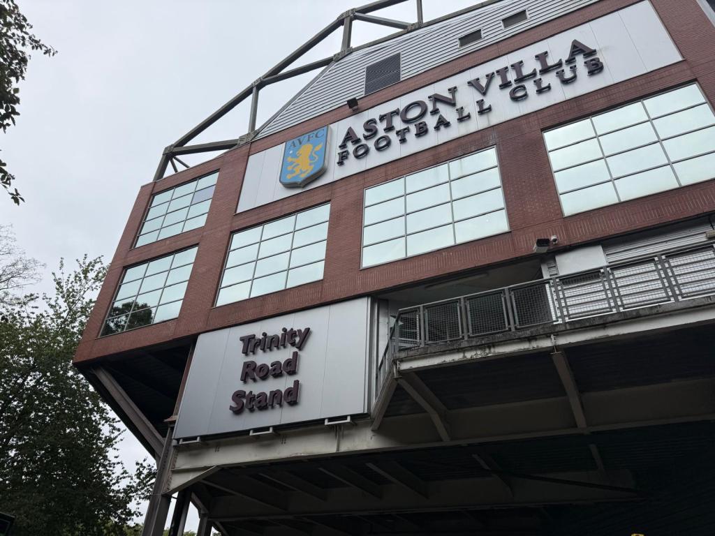 An image of the Trinity Road Stand at Aston Villa Football Club showing the emblem for the team, with its claret and blue colours (as well as some yellow). 
